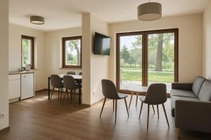 a living room with a couch and a table and chairs at Bursztynowy Horyzont Śliwin obok Rewal , Pobierowo in Śliwin
