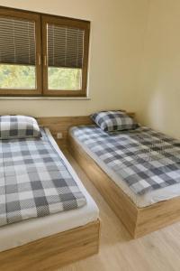 two beds sitting next to each other in a room at Bursztynowy Horyzont Śliwin obok Rewal , Pobierowo in Śliwin