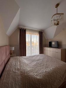 a bedroom with a large bed and a window at Polanki 22 in Łeba