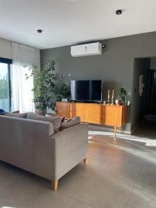 a living room with a couch and a flat screen tv at Terruar Wine in Ciudad Lujan de Cuyo