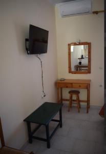 a room with a tv and a table and a mirror at Villa Miranda in Keri