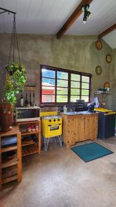 a kitchen with a yellow island in a room at Chalé Joanópolis - Rancho da Biruta in Joanópolis