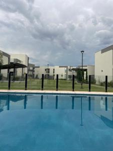 a large swimming pool with buildings in the background at Terruar Wine in Ciudad Lujan de Cuyo