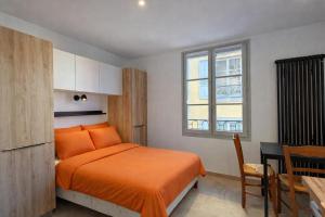 a bedroom with a bed and a table and a window at Les suites Villeneuve - 3 in Le Puy-en-Velay
