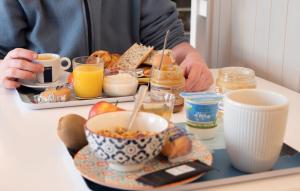 a person sitting at a table with a tray of breakfast food at Fuzei Hôtel Lorient-Lanester in Lanester +37 photos