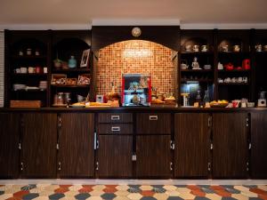 a kitchen with wooden cabinets and a brick wall at Fuzei Hôtel Lorient-Lanester in Lanester