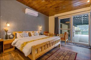 a bedroom with a large bed and a balcony at By the Lakeside in Bhīm Tāl