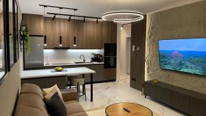 a living room and kitchen with a couch and a tv at Apartmán beige Bardejovské Kúpele in Bardejov