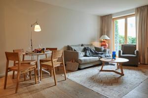 a living room with a table and a couch at Hotel Haus am Meer in Norderney