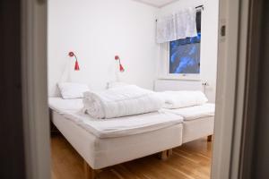 a white room with white sheets and pillows at Hovfjällstoppens Stugby in Överbyn
