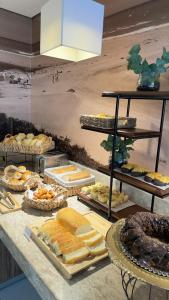 a buffet with many different types of bread and pastries at Linhares Design Hotel in Linhares