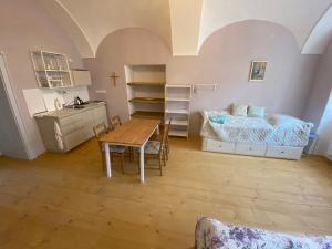 a room with a table and a bed and a kitchen at Klášter Nová Říše in Nová Říše