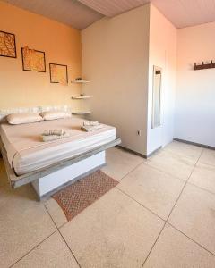 a bedroom with a bed and a room with a rug at La Palma Hostel & Bar in Maragogi