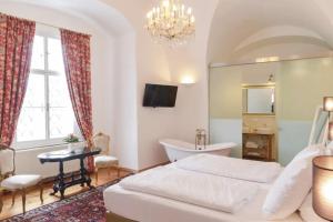 a bedroom with a bed and a tub and a sink at Schlosshotel Mailberg in Mailberg