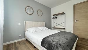 a bedroom with a bed and a clock on the wall at les jumelles villa 1 in Saint-Gaudens