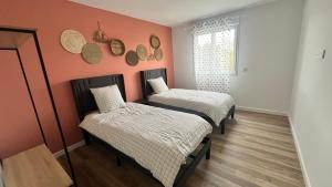two beds in a room with orange walls at les jumelles villa 1 in Saint-Gaudens
