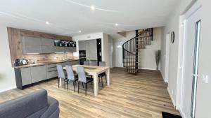 a kitchen and living room with a table and chairs at les jumelles villa 1 in Saint-Gaudens