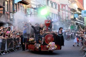 a steam train in a parade with a crowd of people at Casa Próximo ao Centro e Hospital in Blumenau