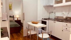 a small kitchen with a table and two chairs at Casa Próximo ao Centro e Hospital in Blumenau