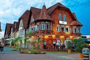 a large building with people standing in front of it at Casa Próximo ao Centro e Hospital in Blumenau