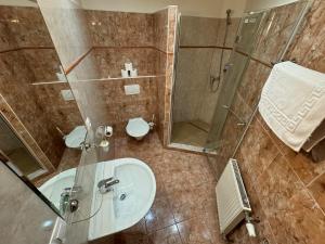 a bathroom with a sink and a shower and a toilet at Pension Euro in Mikulov