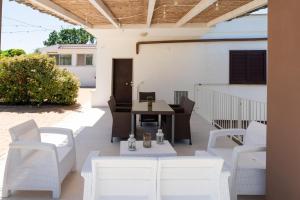 an outdoor patio with white chairs and a table at Villa Irma with Private Pool by Wonderful Italy in Noci