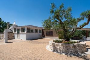 a house with a tree in the middle of a driveway at Villa Irma with Private Pool by Wonderful Italy in Noci