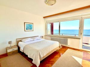 a bedroom with a bed and a large window at Blue View Apartment in Opatija