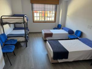 a room with three bunk beds and a window at Albergue el cristo in Porriño