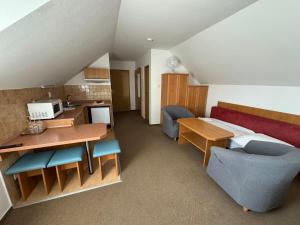 a room with a bed and a desk and a kitchen at Pension Euro in Mikulov