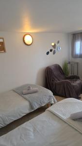 a bedroom with two beds and a light on the wall at Studio atypique avec Piscine à partager en option in La Ferté-Gaucher