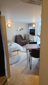 a living room with a table and a couch at Studio atypique avec Piscine à partager en option in La Ferté-Gaucher