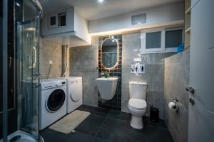 a bathroom with a washing machine and a toilet at Seafront, lovely modern studio. in St. Julianʼs