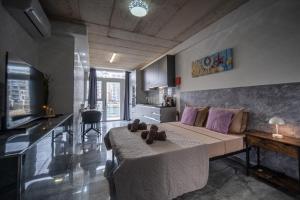 a living room with a bed and a kitchen at Seafront, lovely modern studio. in St. Julianʼs