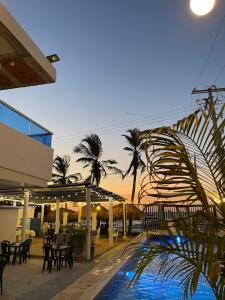 a resort with a pool and tables and palm trees at Palmarena in Puerto Viejo