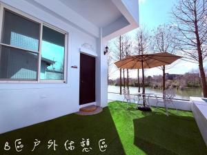 a patio with an umbrella and a table and chairs at 夢幻城堡民宿 in Wujie