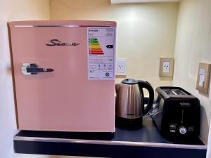 a pink refrigerator sitting on a counter next to a toaster at Posada Patagonia San Juan in Pocito