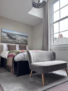 a bedroom with a bed and a chair and a window at Fleur De Lis Hotel in Sandwich