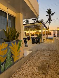 a building with a patio with tables and chairs at Palmarena in Puerto Viejo