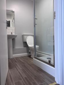 a bathroom with a toilet and a glass shower at Fleur De Lis Hotel in Sandwich