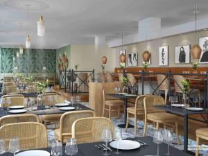 a restaurant with tables and chairs in a room at Mercure Parkhotel Mönchengladbach in Mönchengladbach