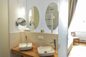 a bathroom with two mirrors and a sink at Schlosshotel Mailberg in Mailberg +20 photos