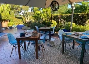 a patio with tables and chairs under an umbrella at La Casa di SASI in Sabaudia