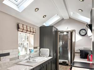 a kitchen with two sinks and a clock on the ceiling at Jasmine Cottage in Grassington