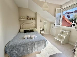 two stuffed animals sitting on a bed in a bedroom at Apartamento Somo 30608 in Somo