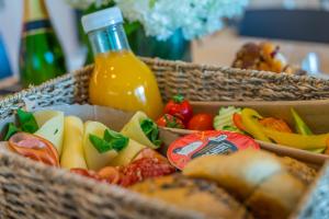 a basket of food with a bottle of orange juice at BJ81 Suite Hotel in Siófok