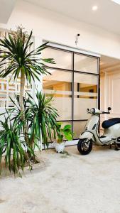a scooter parked in front of a building with palm trees at azafa hotel in Lamobuang