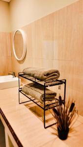 a bathroom with a rack of towels and a mirror at azafa hotel in Lamobuang