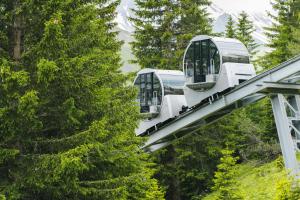 a gondola ride in the mountains with trees at Tschuggen Grand Hotel - The Leading Hotels of the World in Arosa