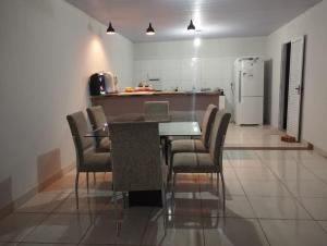 a kitchen with a table and chairs and a refrigerator at Casa charmosa familiar in Chapada dos Guimarães